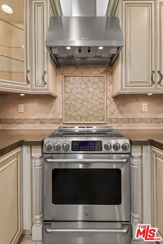 a large kitchen with stainless steel appliances granite countertop a stove and a refrigerator