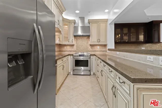 a kitchen with stainless steel appliances granite countertop a refrigerator and a sink