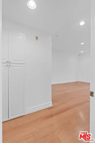 a view of an empty room with wooden floor and stairs