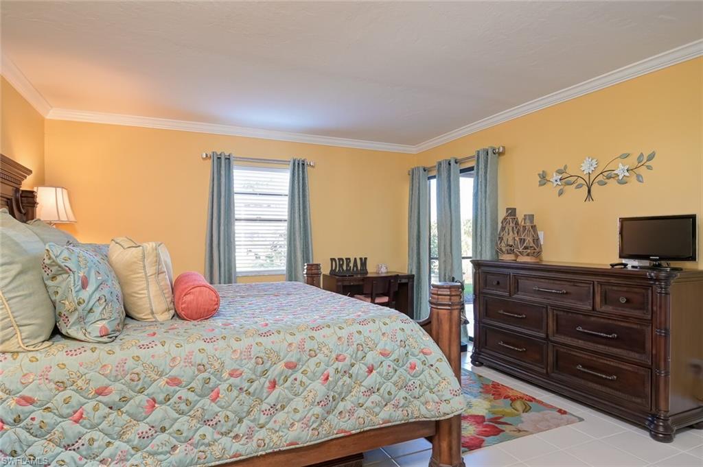 145 Cypress Way East, Unit A Naples, FL 34110 - Photo 11 of 24 a bedroom with a bed and dresser