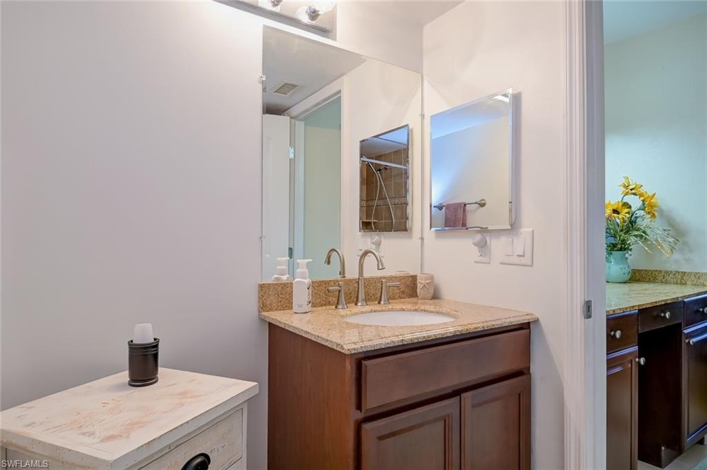 145 Cypress Way East, Unit A Naples, FL 34110 - Photo 13 of 24 a bathroom with a sink and a mirror