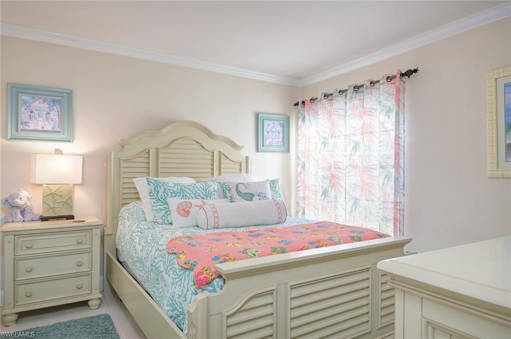 145 Cypress Way East, Unit A Naples, FL 34110 - Photo 15 of 24 a bedroom with a bed and a dresser in it