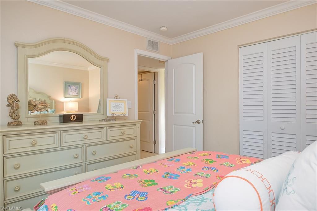 145 Cypress Way East, Unit A Naples, FL 34110 - Photo 16 of 24 a bedroom with a bed and a dresser