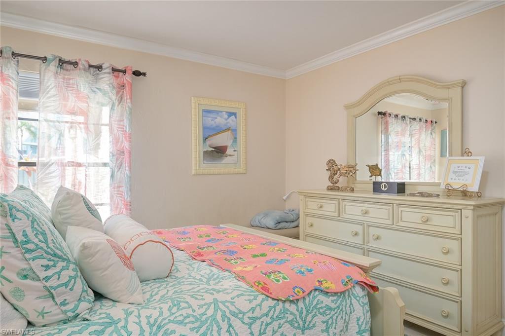145 Cypress Way East, Unit A Naples, FL 34110 - Photo 17 of 24 a bedroom with a bed and a dresser