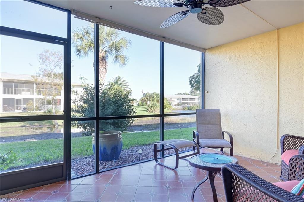 145 Cypress Way East, Unit A Naples, FL 34110 - Photo 20 of 24 a living room with hardwood floor and a floor to ceiling window