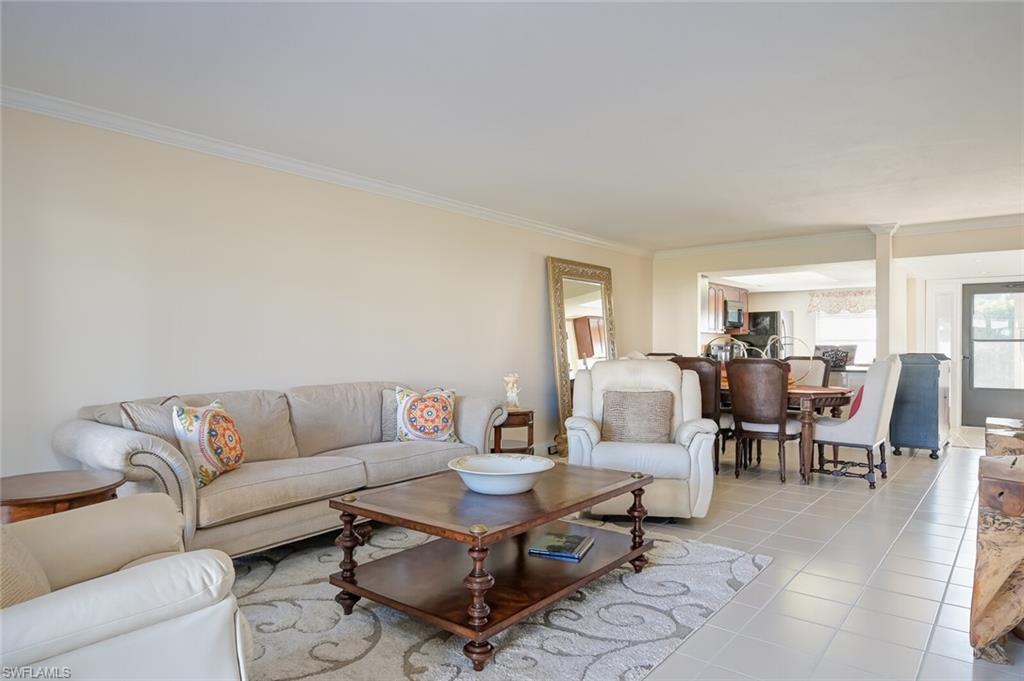 145 Cypress Way East, Unit A Naples, FL 34110 - Photo 2 of 24 a living room with furniture wooden floor and a window