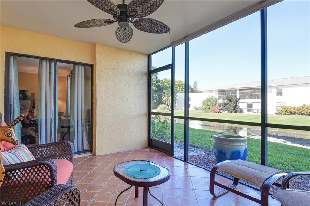 145 Cypress Way East, Unit A Naples, FL 34110 - Photo 21 of 24 a living room with furniture and a floor to ceiling window