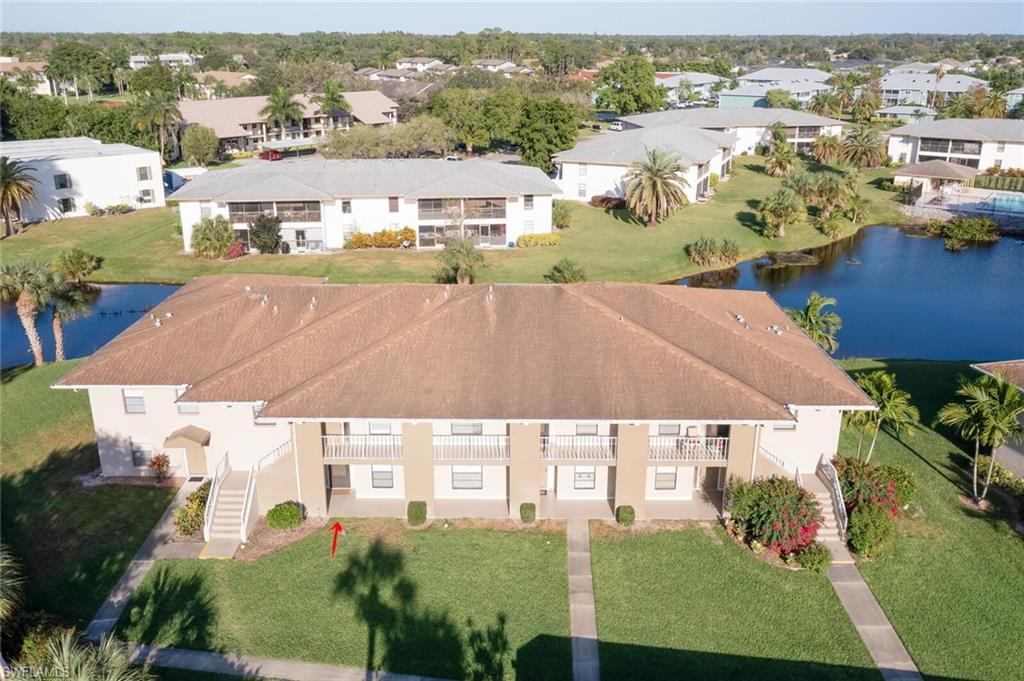 145 Cypress Way East, Unit A Naples, FL 34110 - Photo 22 of 24 an aerial view of multiple houses with a yard