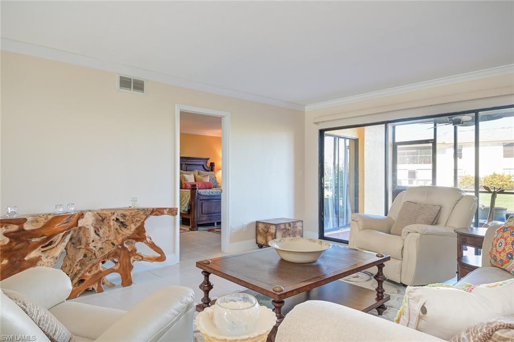 145 Cypress Way East, Unit A Naples, FL 34110 - Photo 4 of 24 a living room with furniture and a large window