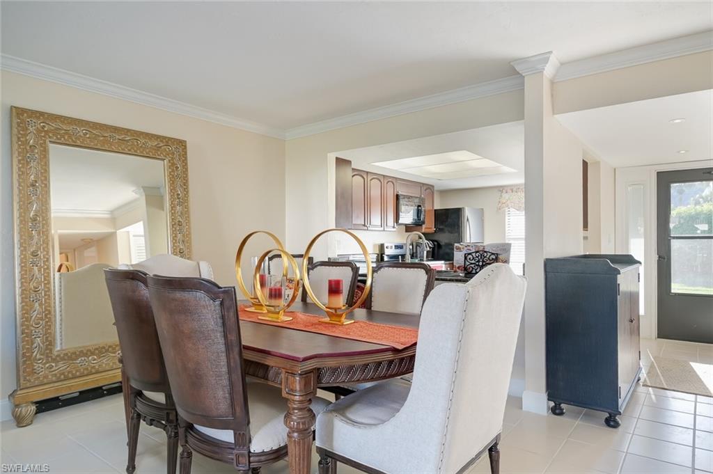 145 Cypress Way East, Unit A Naples, FL 34110 - Photo 6 of 24 a view of a dining room with furniture and window