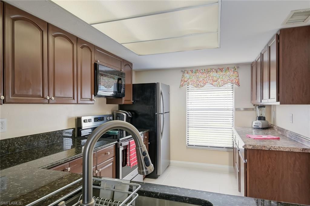 145 Cypress Way East, Unit A Naples, FL 34110 - Photo 7 of 24 a view of a kitchen with fridge and window