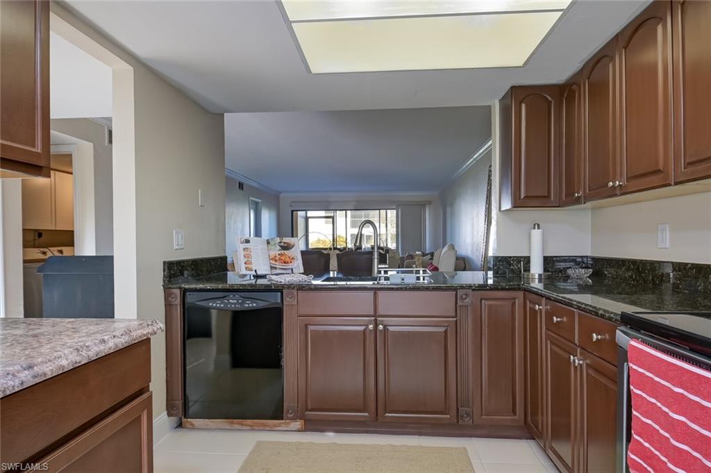 145 Cypress Way East, Unit A Naples, FL 34110 - Photo 9 of 24 a kitchen with a sink and cabinets