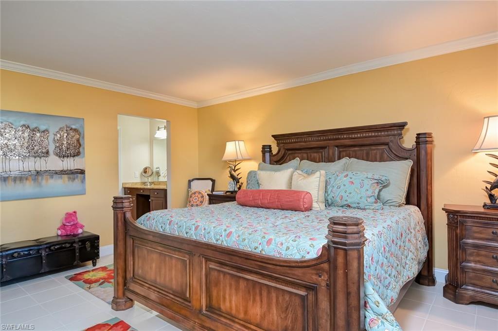 145 Cypress Way East, Unit A Naples, FL 34110 - Photo 10 of 24 a bedroom with a bed and wooden floor