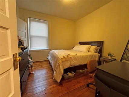 a bedroom with a bed and wooden floor