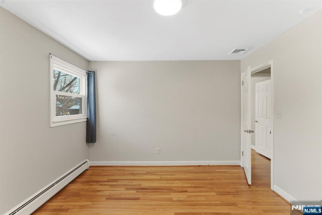 3 Rutgers Court Roseland, NJ 07068 - Photo 18 of 29 a view of an empty room with wooden floor and a window