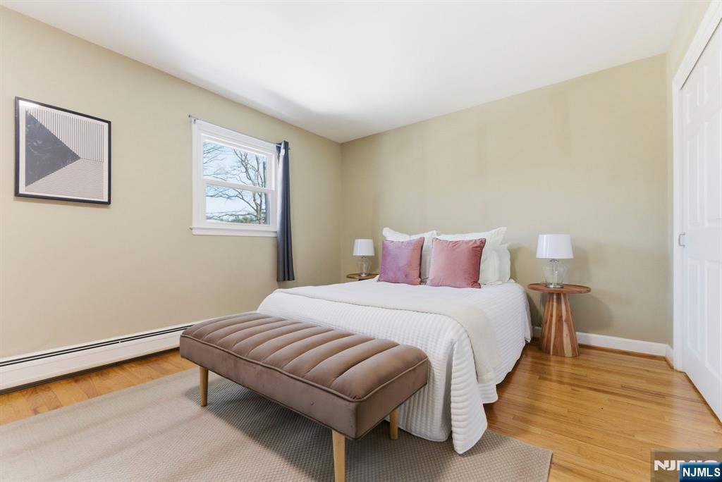 3 Rutgers Court Roseland, NJ 07068 - Photo 22 of 29 a bedroom with a bed and wooden floor