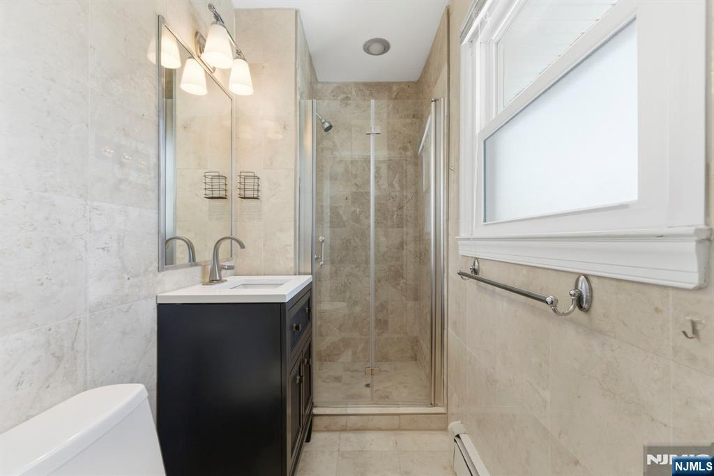 3 Rutgers Court Roseland, NJ 07068 - Photo 24 of 29 a bathroom with a sink a mirror and a shower