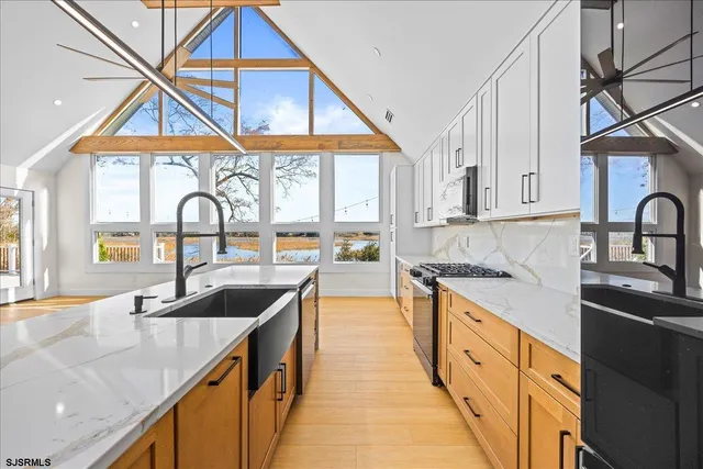 a view of kitchen with stainless steel appliances granite countertop a stove and a refrigerator