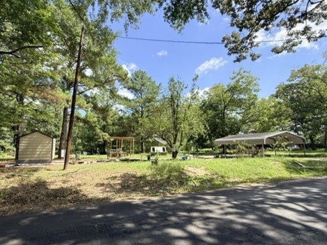 58 Roy Webb Road Huntsville, TX 77320 - Photo 26 of 31 This is a view from the street where the manufactured home was located. The metal double car carport and metal storage shed conveys with the property.