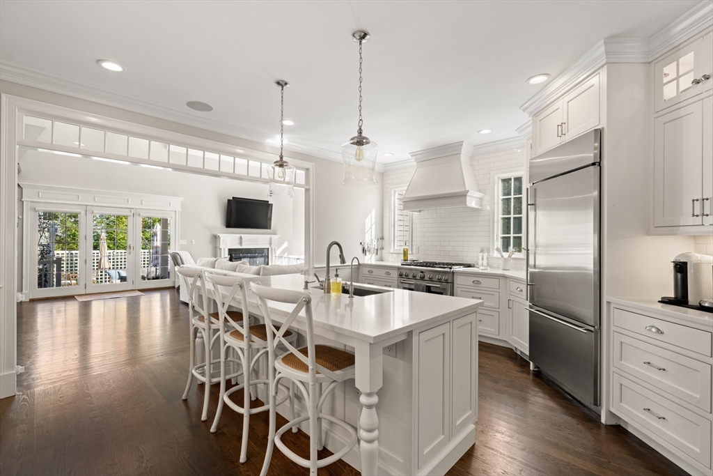 120 Deerfield Lane Hanover, MA 02339 - Photo 9 of 42 a kitchen with stainless steel appliances kitchen island granite countertop a stove a refrigerator a oven and a dining table with wooden floor