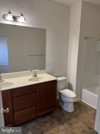 a bathroom with a sink vanity mirror and toilet
