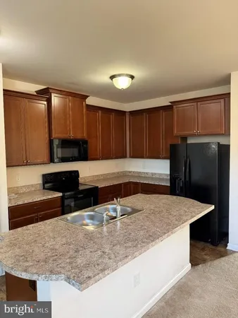 a kitchen with stainless steel appliances granite countertop a sink a stove and a refrigerator