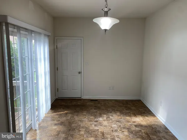 a view of a room with a chandelier fan and a window