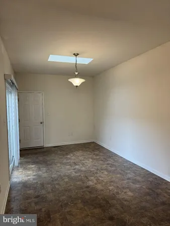 a view of an empty room with a chandelier fan