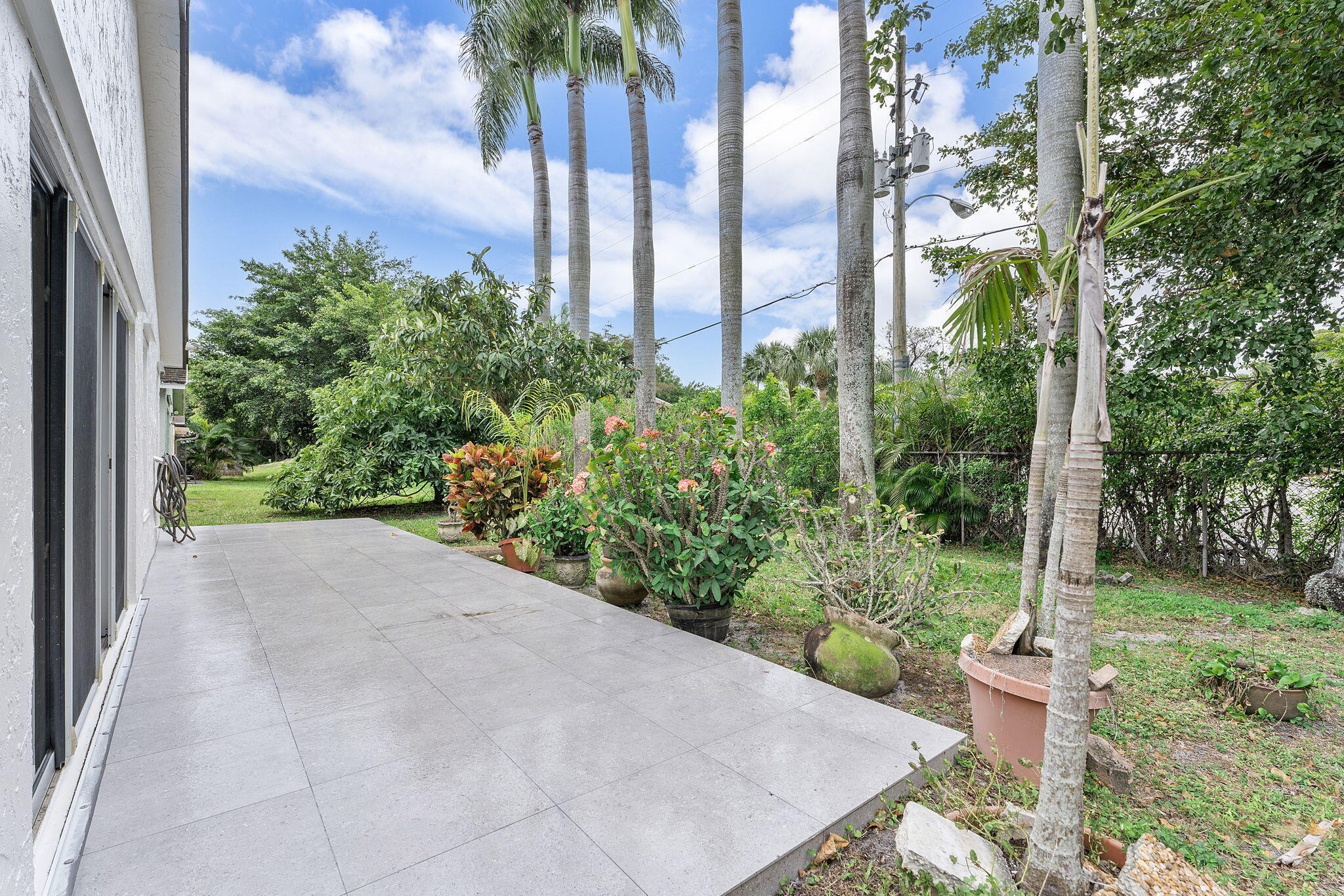 9180 Pine Springs Drive Boca Raton, FL 33428 - Photo 26 of 29 a view of a backyard with potted plants and palm trees
