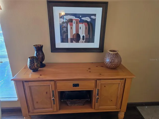 a bedroom with a bed a painting on the wall and a baby crib