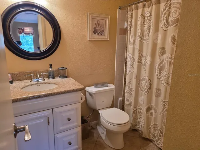 a bathroom with a granite countertop double vanity sink and a mirror