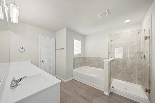 a bathroom with a tub shower and mirror