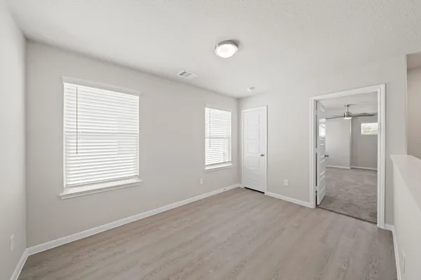 a view of an empty room with window and closet area