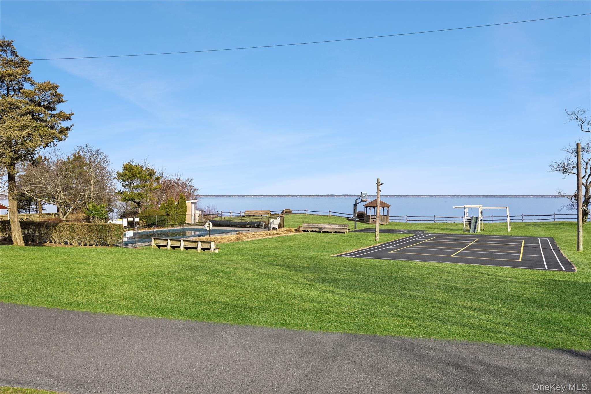 67 North Road, Unit A Hampton Bays, NY 11946 - Photo 12 of 17 View of property's community featuring a yard and a water view