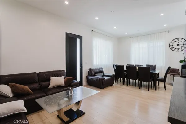 a living room with furniture and a dining table with rug