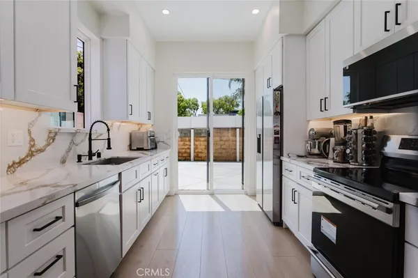 a kitchen with stainless steel appliances a sink stove top oven and refrigerator