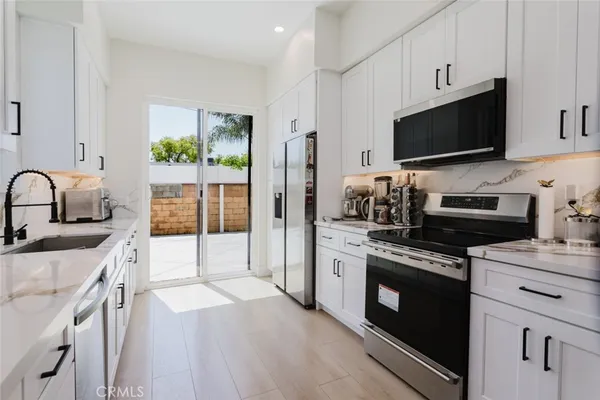 a kitchen with stainless steel appliances a stove sink microwave and cabinets