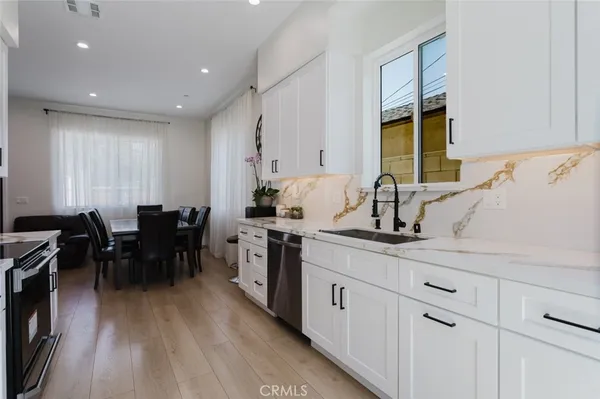 a kitchen with sink dining table and chairs