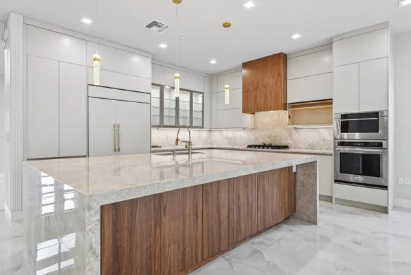a kitchen with stainless steel appliances granite countertop a refrigerator and a stove top oven