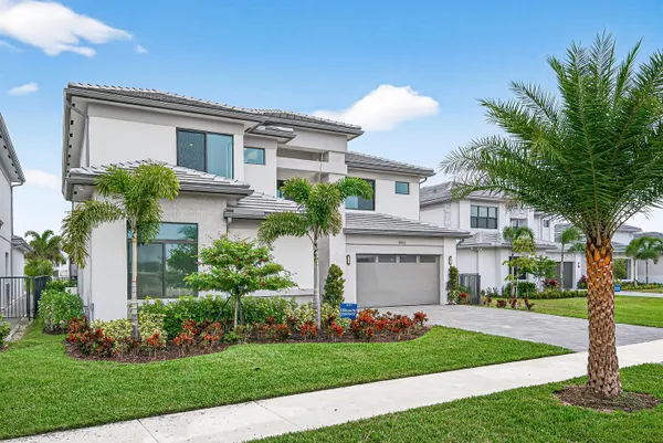 a front view of a house with a garden and garage