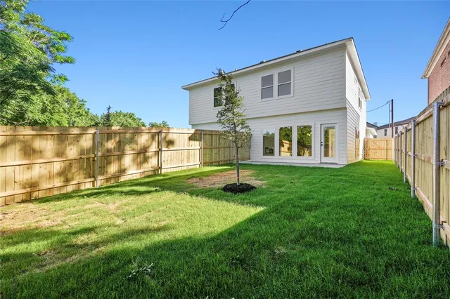 a backyard of a house with a garden and barbeque oven