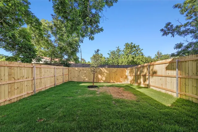 a view of a backyard with a wooden fence