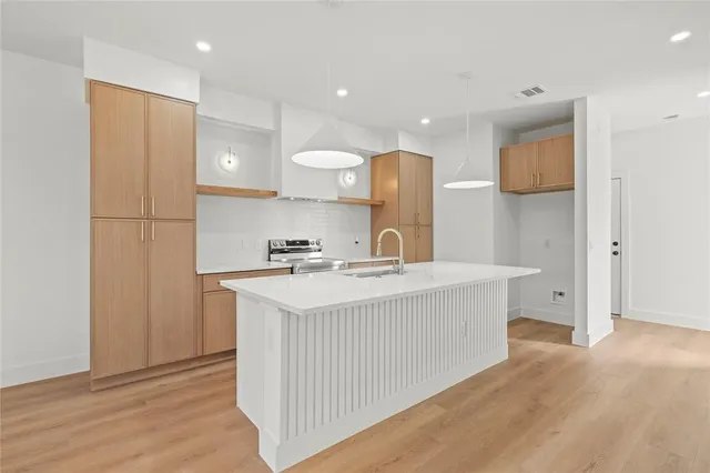 a kitchen with a sink a refrigerator and a stove top oven