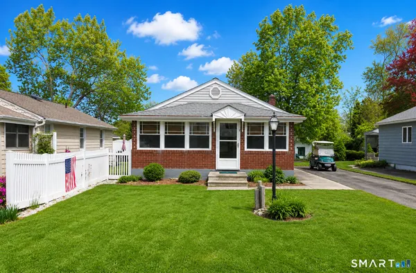 a view of a house with a yard and sitting area