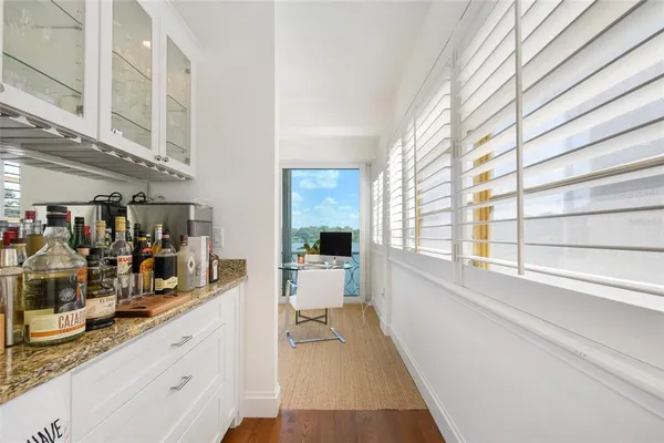 a kitchen with stainless steel appliances a stove a sink dishwasher a refrigerator and white cabinets with wooden floor