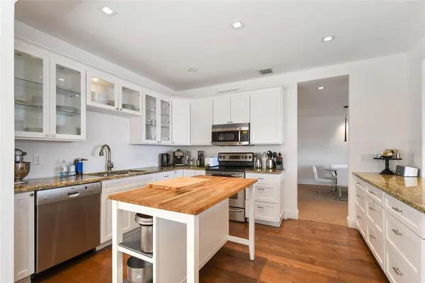 a kitchen with stainless steel appliances granite countertop a stove and a sink