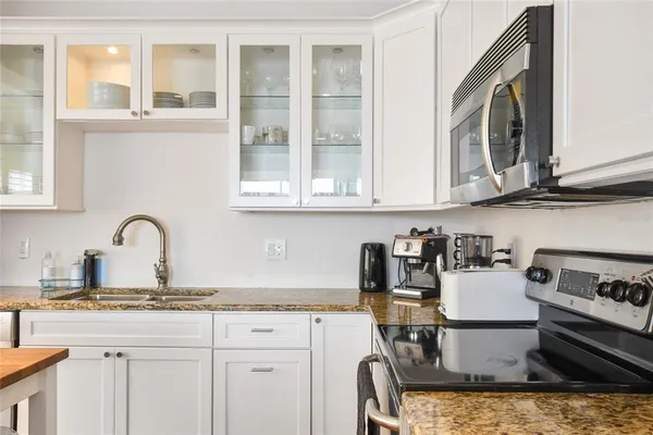 a kitchen with a stove a sink and cabinets
