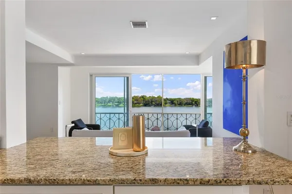 a kitchen with granite countertop a sink stainless steel appliances and white cabinets