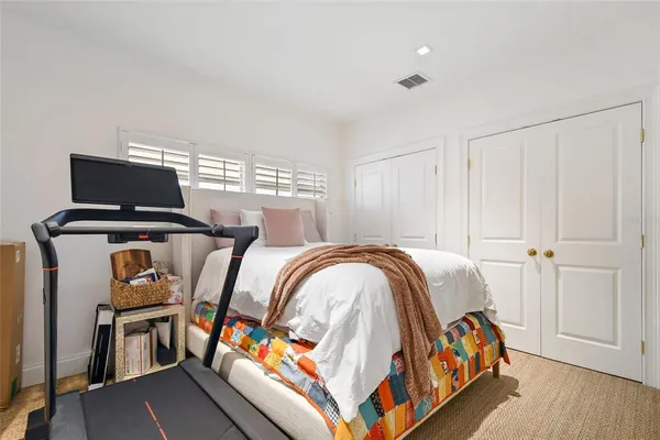 a bedroom with a bed couch and a flat tv screen