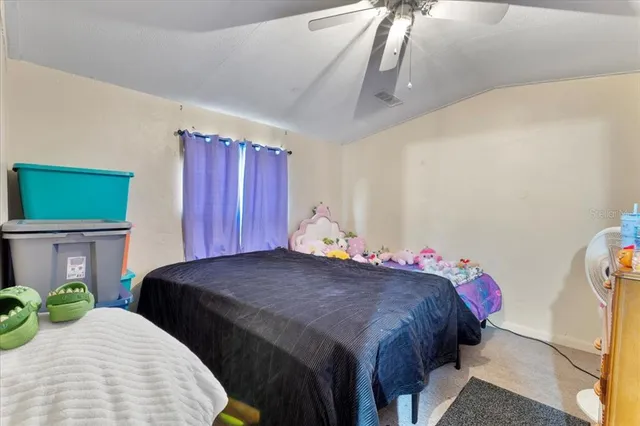a bedroom with a bed a dresser and potted plants